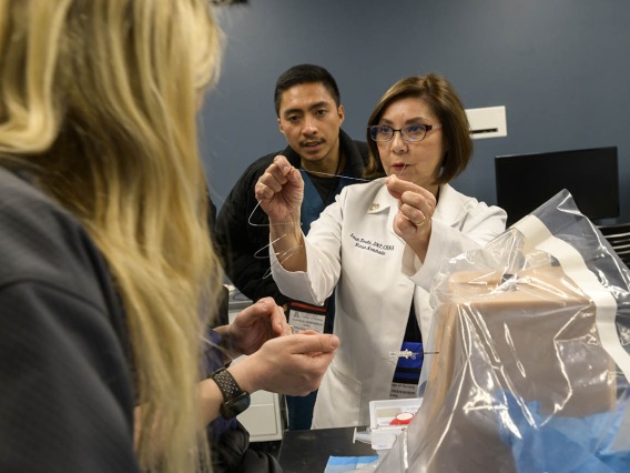 UArizona College of Nursing professor reviews the instruments needed for a spinal tap with Doctor of Nursing Practice students during a clinical immersion session. 
