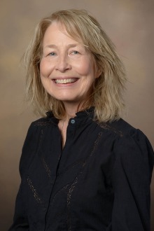 Portrait of a woman with shoulder-length blonde hair. 