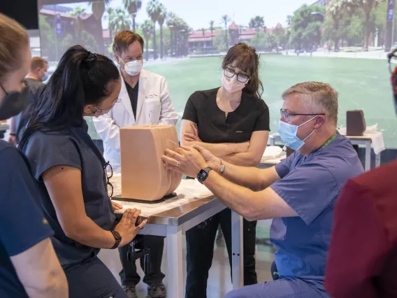 Chris Herring, DNP, CRNA, demonstrates lumbar puncture techniques to Adult-Gerontology Acute Care Nurse Practitioner (AGACNP) students at ASTEC. The ACAGNP clinicians use this technique to collect samples of cerebral spinal fluid  to assist in the diagnosis of diseases of   the neurological system.