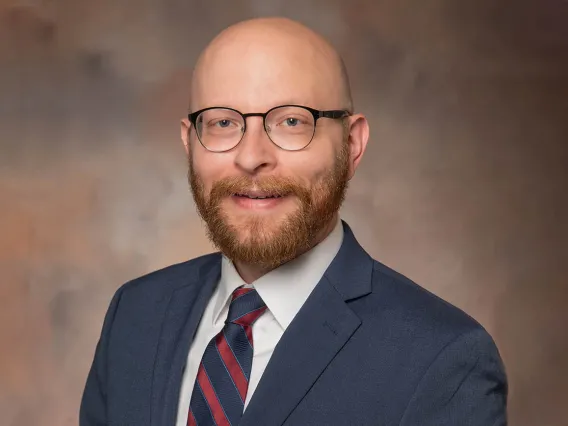 Portrait of Dr. Christopher Edwards, wearing glasses, a suit and tie.