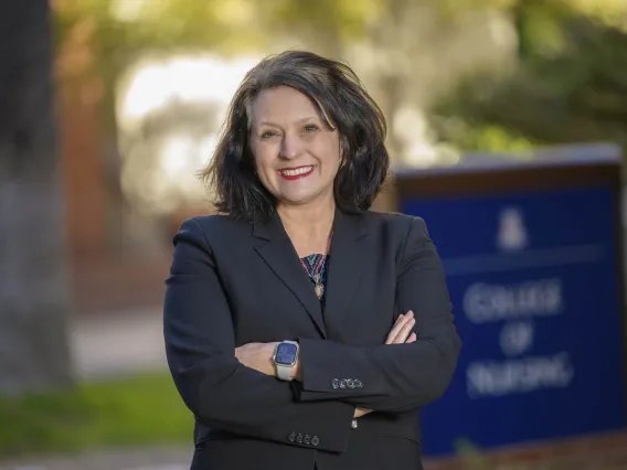 Portrait of Dr. Sheila Gephart standing outside with her arms crossed and smiling. 