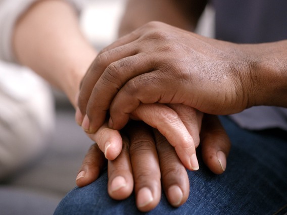 close-up of two hands clasped together in a show of support