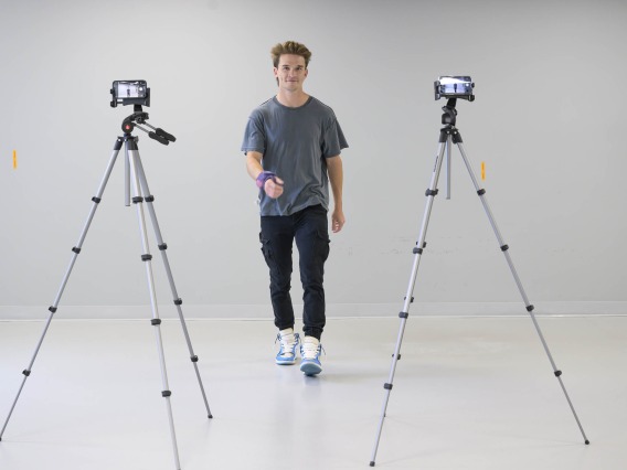 a study participant walking toward two cameras set up on tripods in an empty room at the University of Arizona Health Sciences