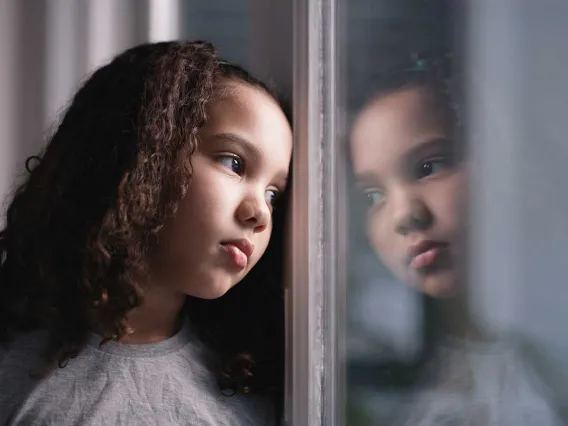 Girl looking out a window and thinking