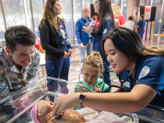 Volunteers from the University of Arizona College of Nursing check infant manikin for a heartbeat inside the Wildcat Play Hospital.
