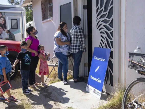 People gather outside a community center for a MOVE-UP clinic hosted by UArizona Health Sciences in the rural town of Aguila, Arizona, to get COVID-19 vaccine shots.