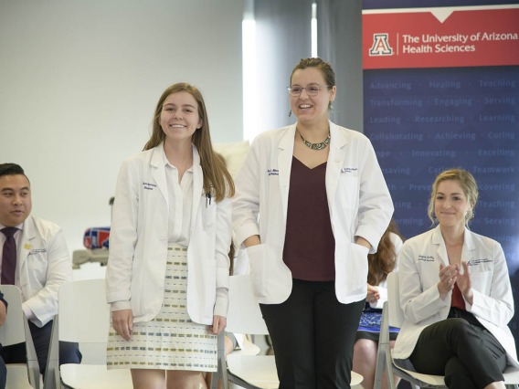 Primary Care Physician scholarship recipients Merrion Dawson and Kathryn Blevins stand as their names are announced during the reception. 