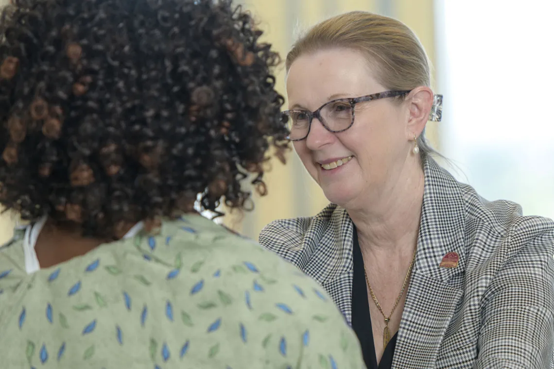 Smiling female physician examining African-American patient.