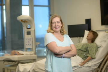 Erin McMahon, EdD, CNM, pictured in front of a birthing manikin in the Arizona Simulation Technology and Education Center, says there has been a push to increase the number of academic midwifery programs graduating more nurse-midwives.