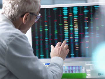 Scientist comparing DNA reults on a computer screen